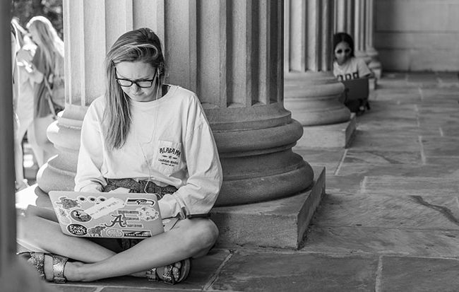 students sitting against the pillars on the Gorgas Library steps